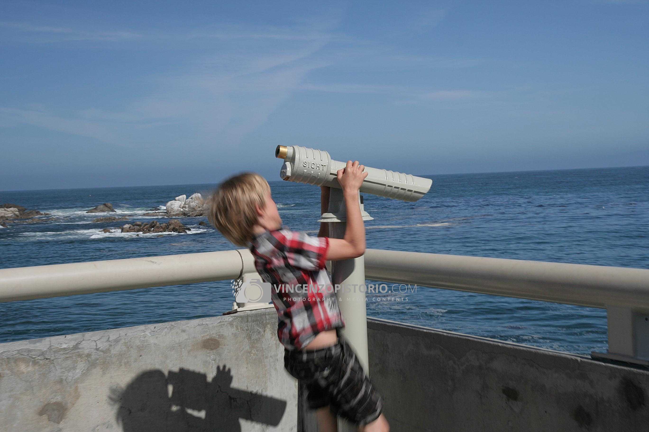 A boy playing with a spotting scope